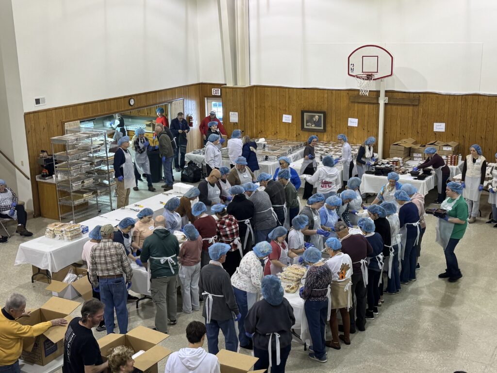 Volunteers putting together Thanksgiving meals for delivery